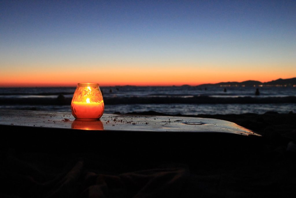 Kerze am Wasser als spirituelle Gabe. Den Rest mitnehmen, um weniger Plastik in die Natur zu bringen.